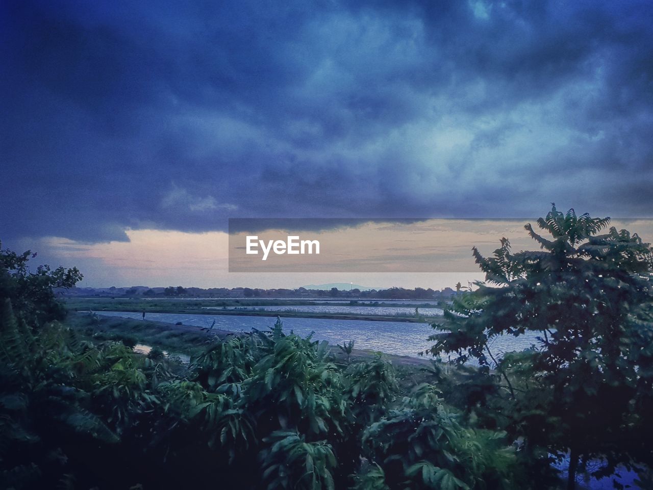 SCENIC VIEW OF BEACH AGAINST SKY AT SUNSET