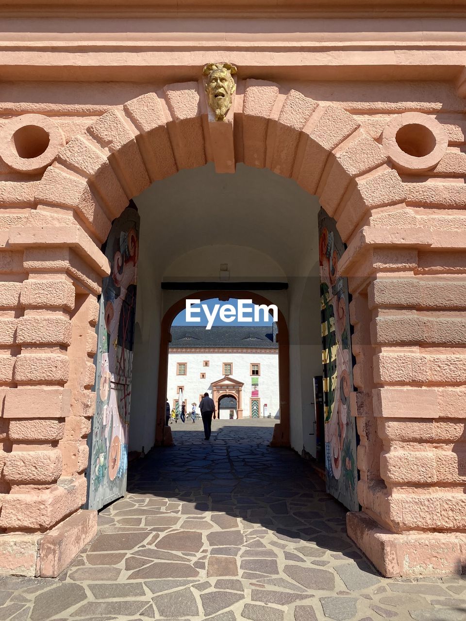 architecture, arch, built structure, travel destinations, adult, travel, building exterior, entrance, men, history, tourism, day, sunlight, nature, the past, city, building, wall, outdoors, full length, ancient history, estate, tourist, door, two people, walking, women, brick