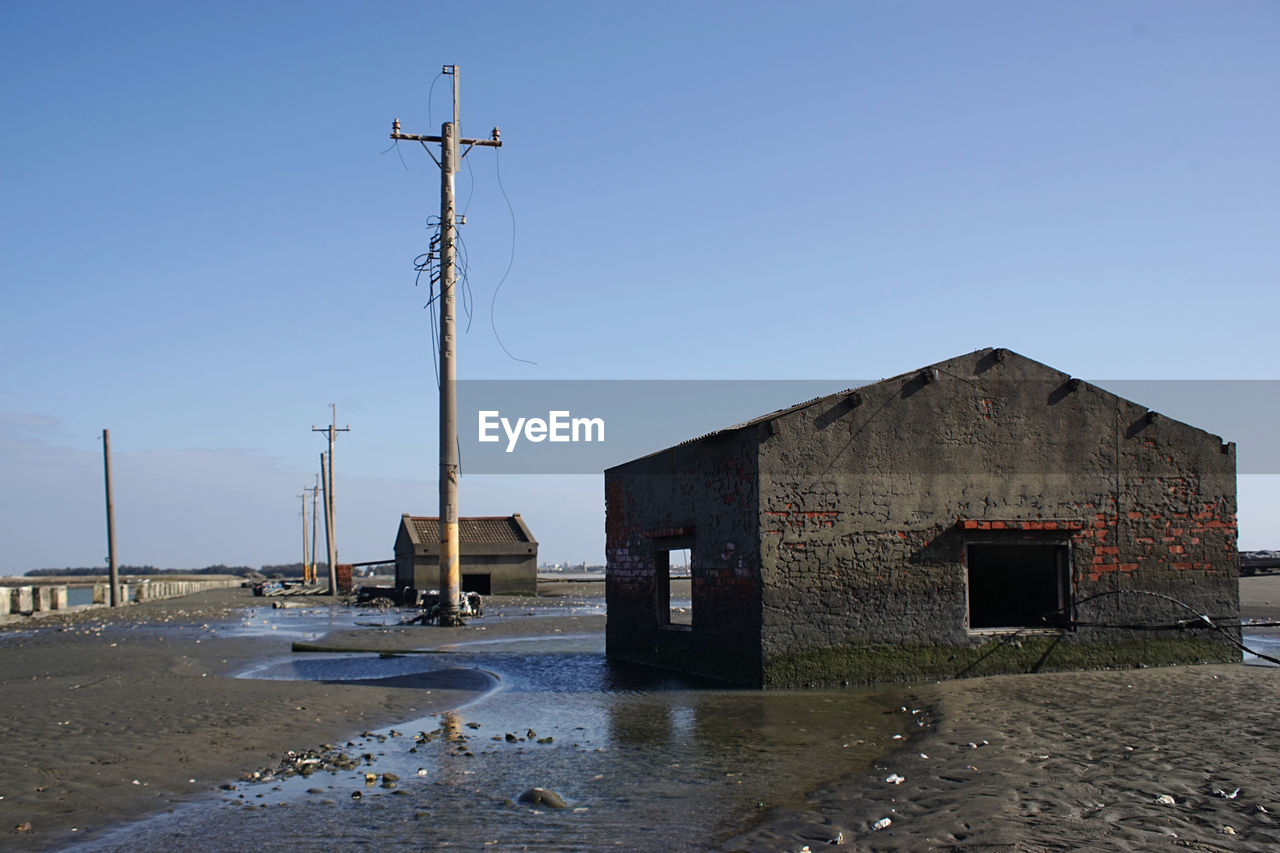 architecture, built structure, sky, building exterior, nature, clear sky, water, building, no people, day, land, blue, sea, technology, outdoors, power generation, street, business finance and industry, tower, city, landscape, coast, industry, house, sunny, environment