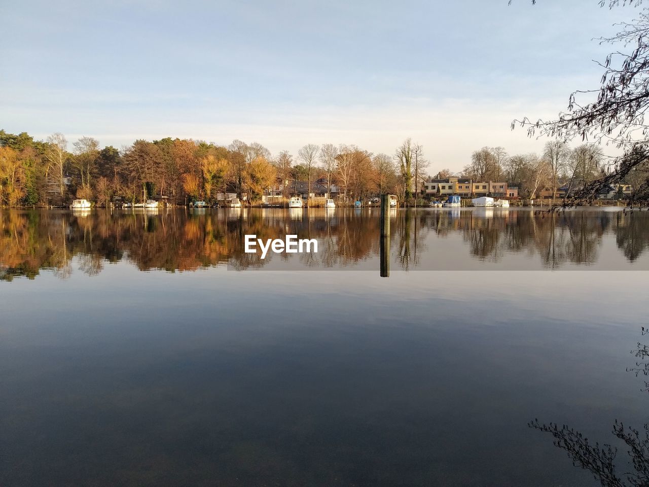 REFLECTION OF TREES IN LAKE AGAINST SKY