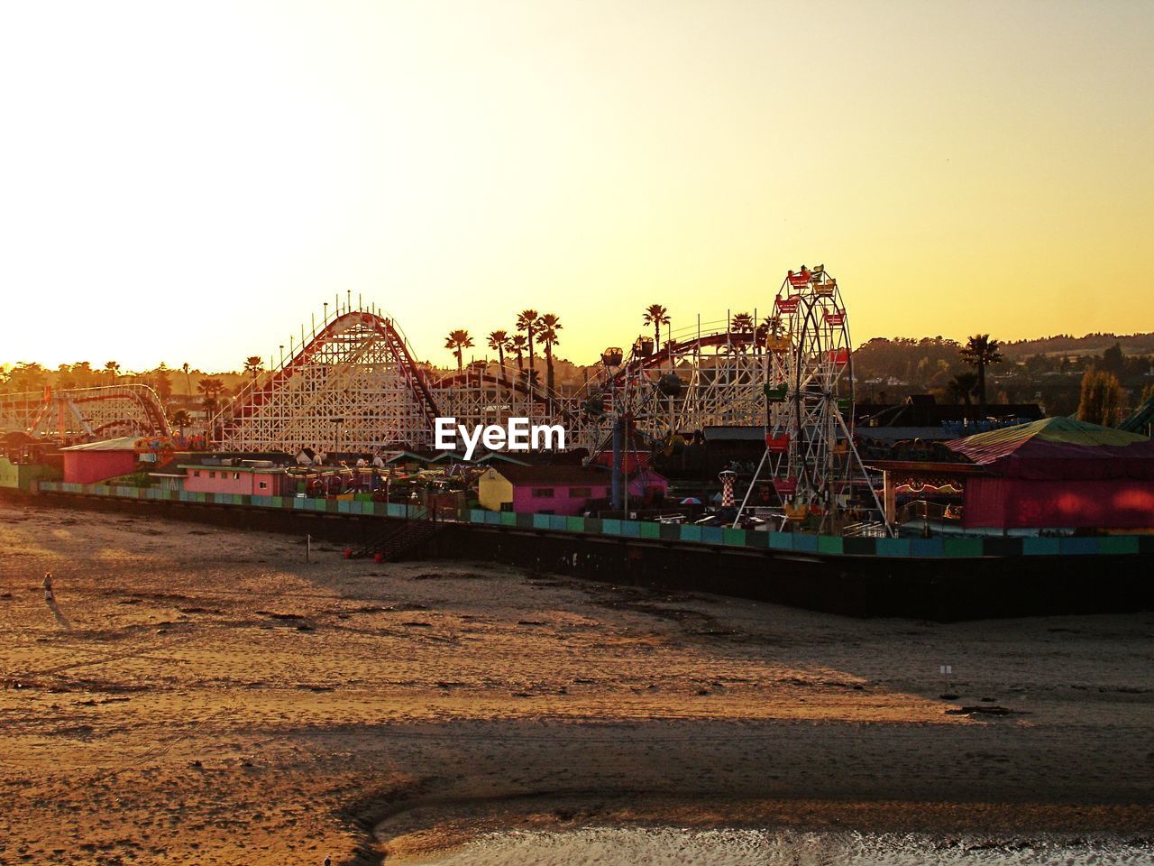 View of rides against clear sky at amusement park