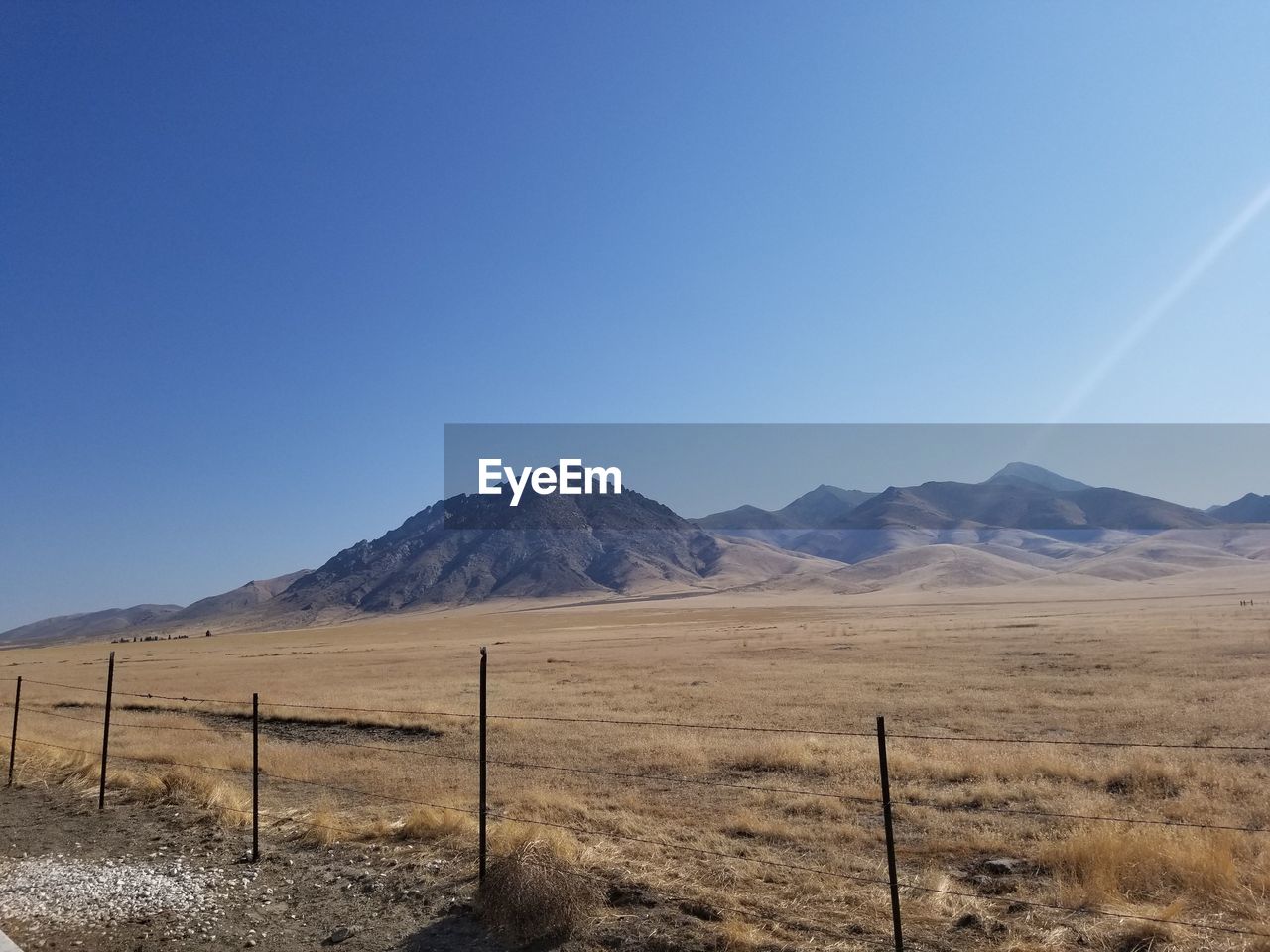 SCENIC VIEW OF FIELD BY MOUNTAINS AGAINST CLEAR SKY