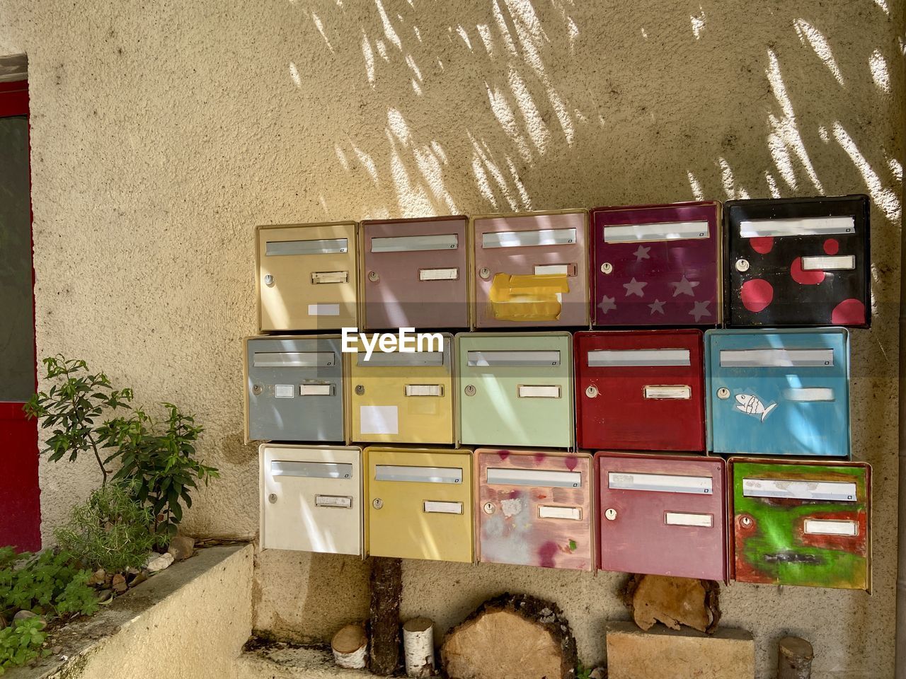 Close-up of rows of colourful mailboxes against wall