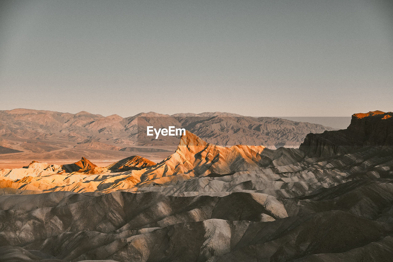 Morning sunlight on a prominent rock formation against a clear sky