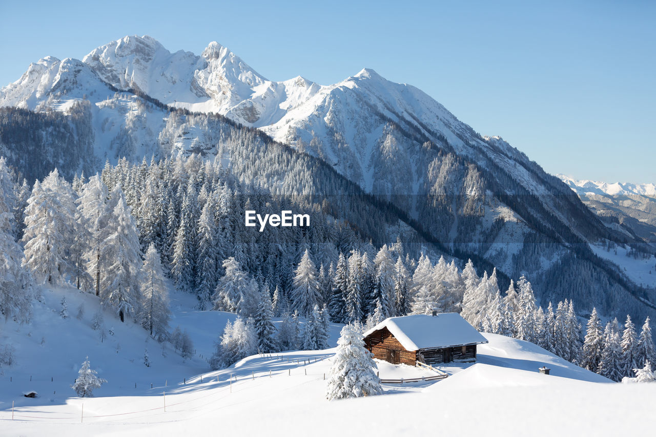Picturesque winter scene with traditional alpine chalet. snowy wintertime landscape 