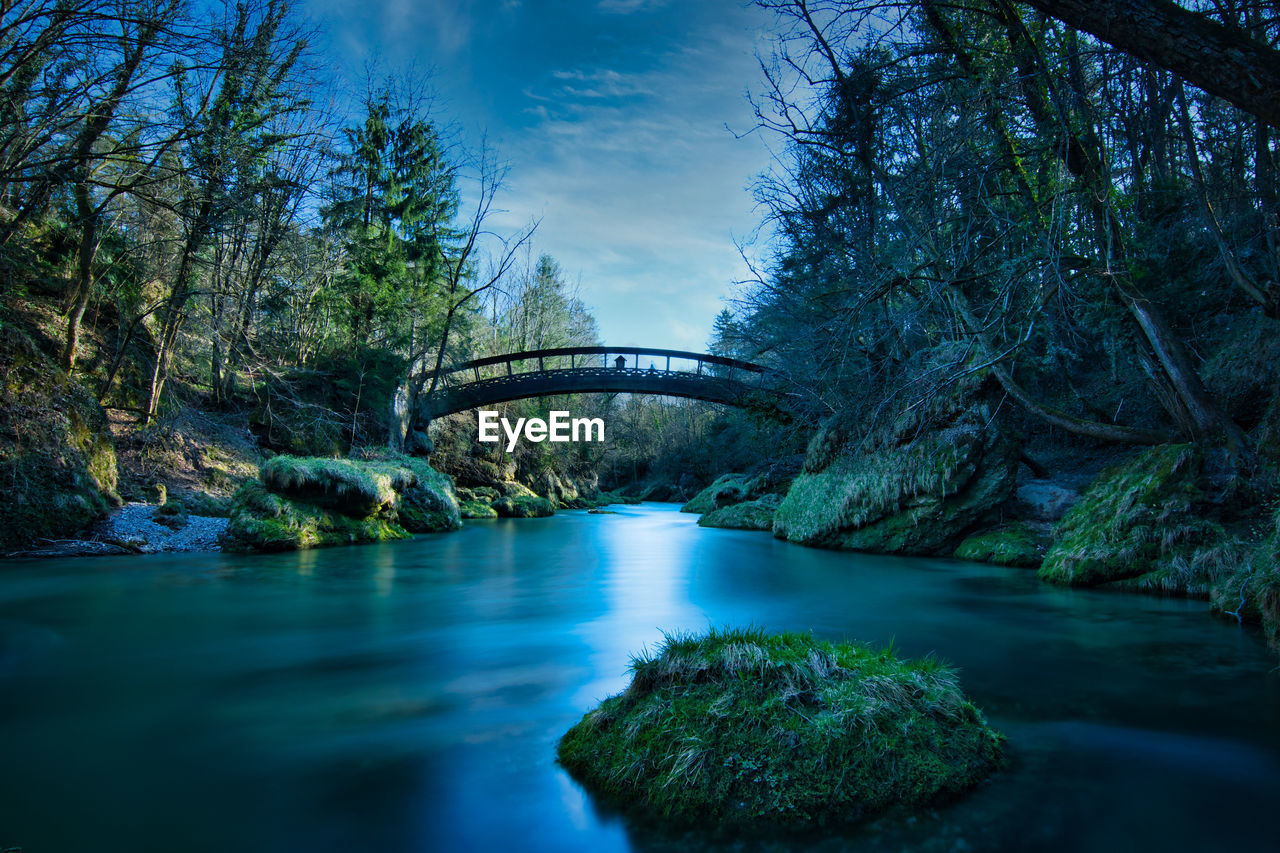 Arch bridge over river against sky