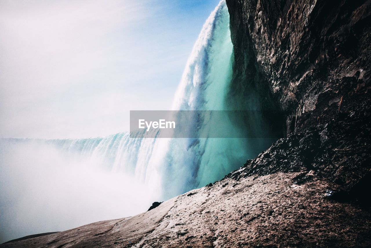 Scenic view of waterfall against sky