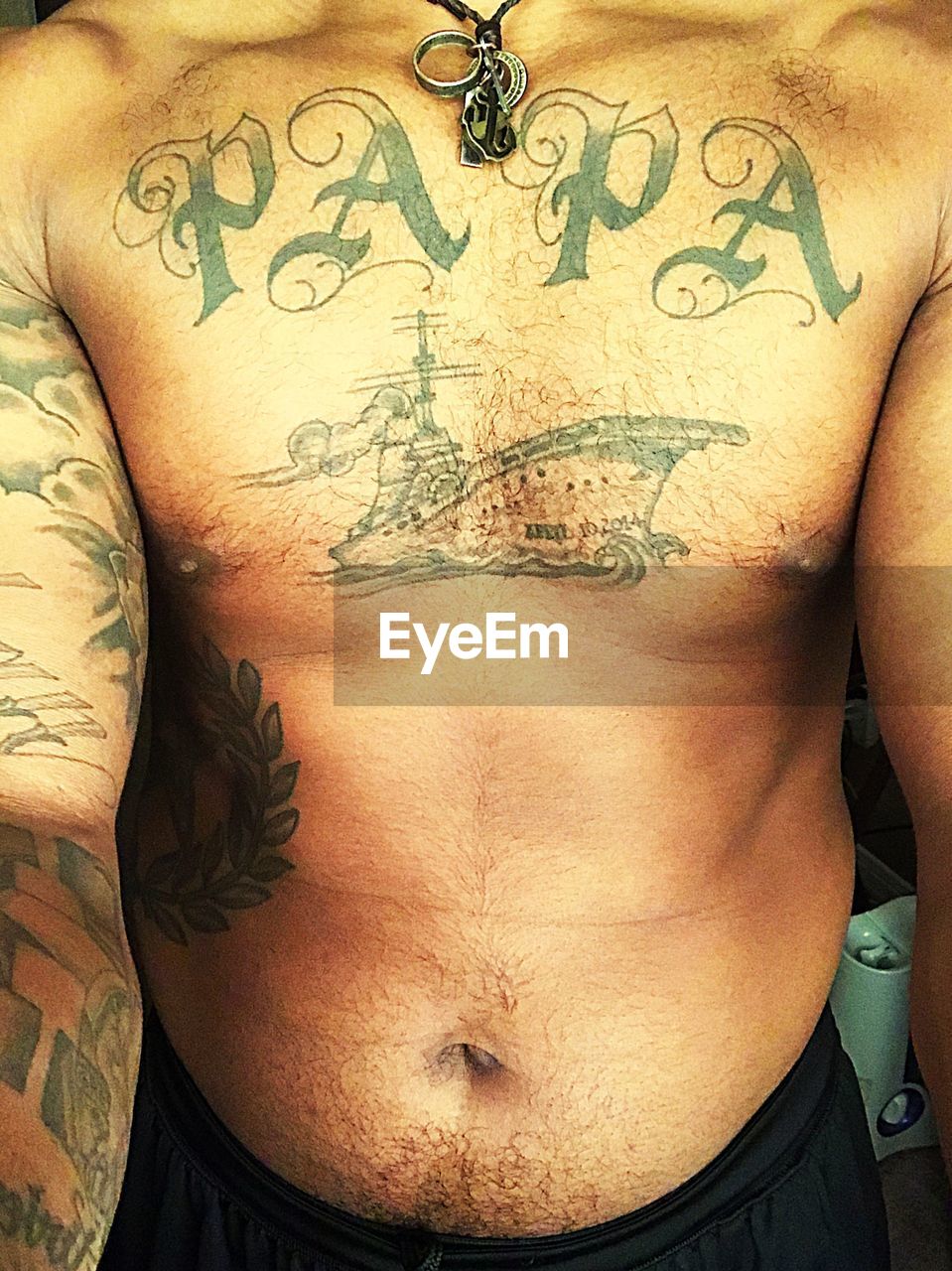 MIDSECTION OF SHIRTLESS MAN WITH TATTOO