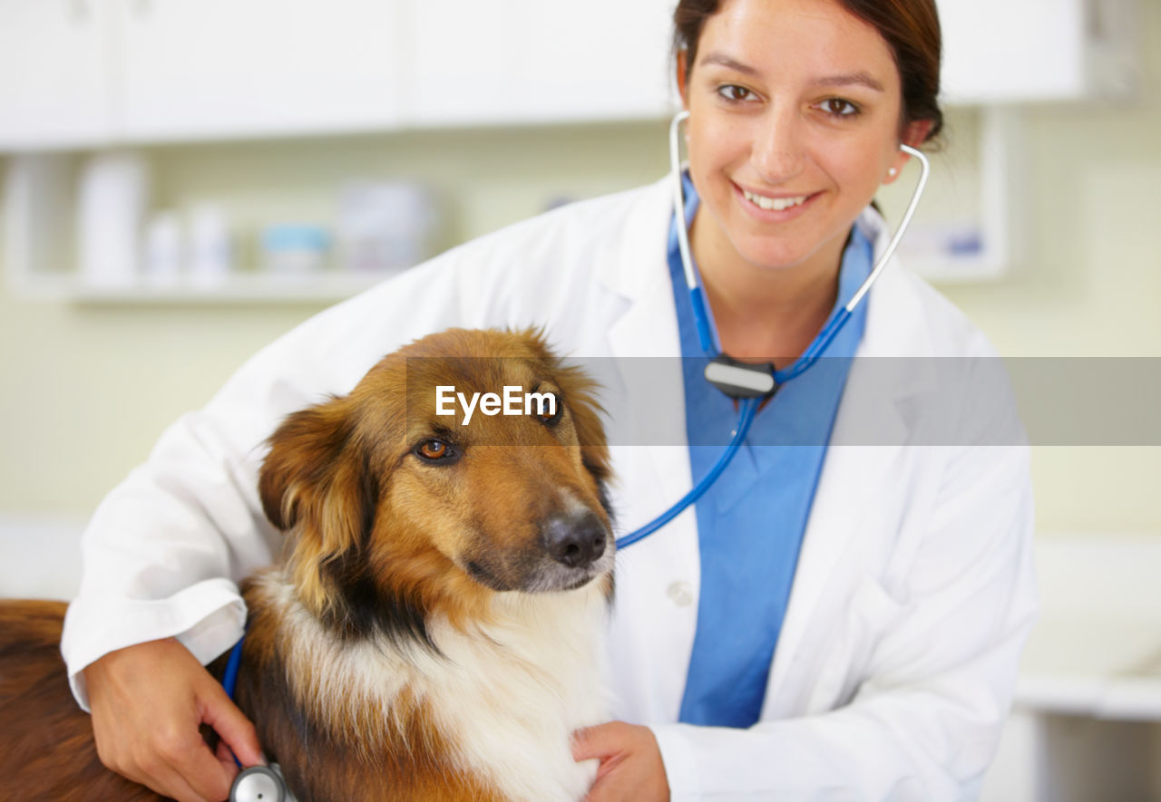 Portrait of veterinarian with dog in clinic