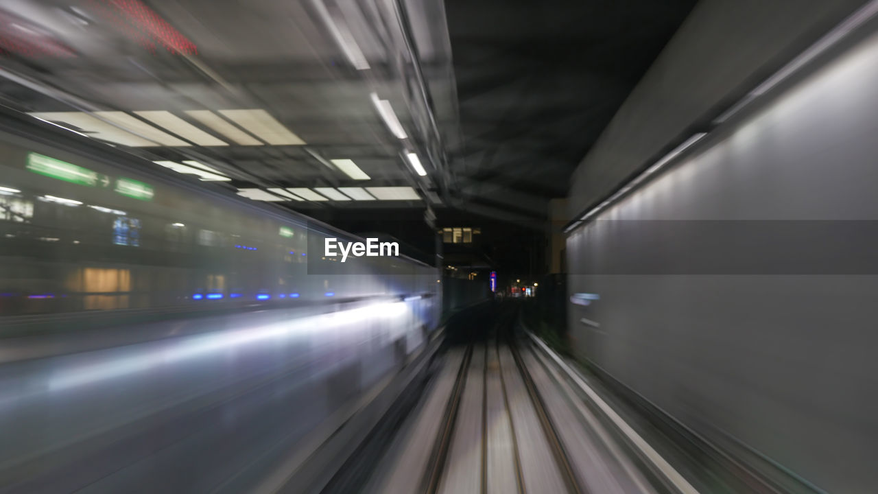 Blurred image of train moving at station during night
