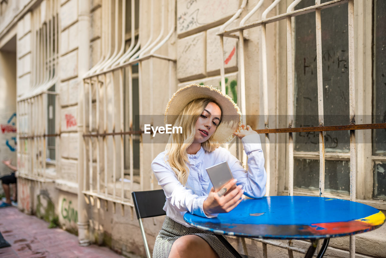 Young woman using mobile phone on table