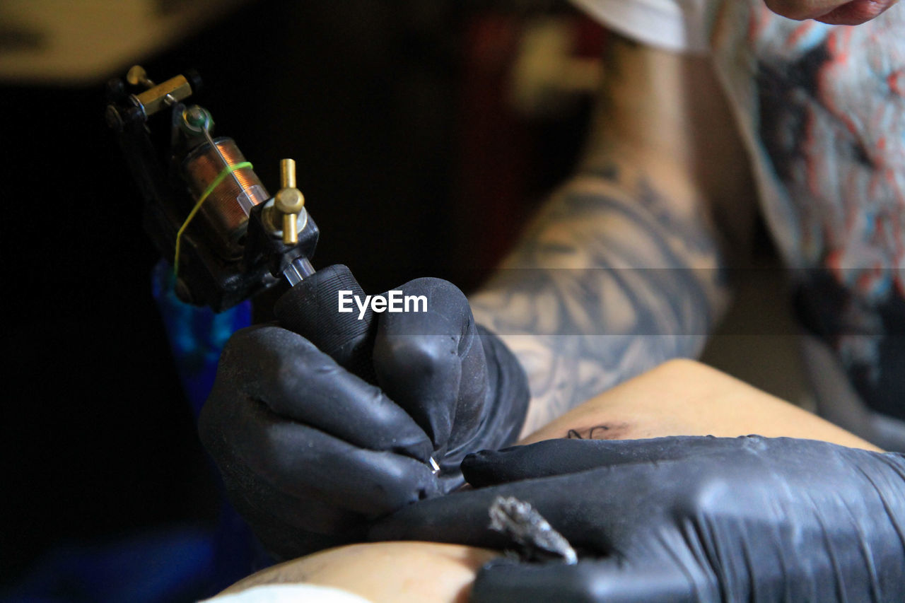 Close-up of man making tattoo