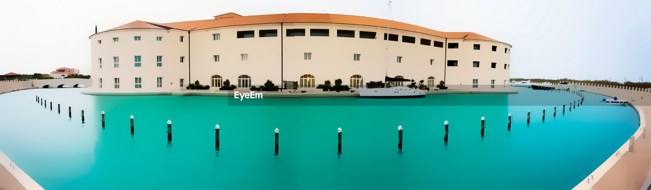 SWIMMING POOL BY BUILT STRUCTURE AGAINST SKY