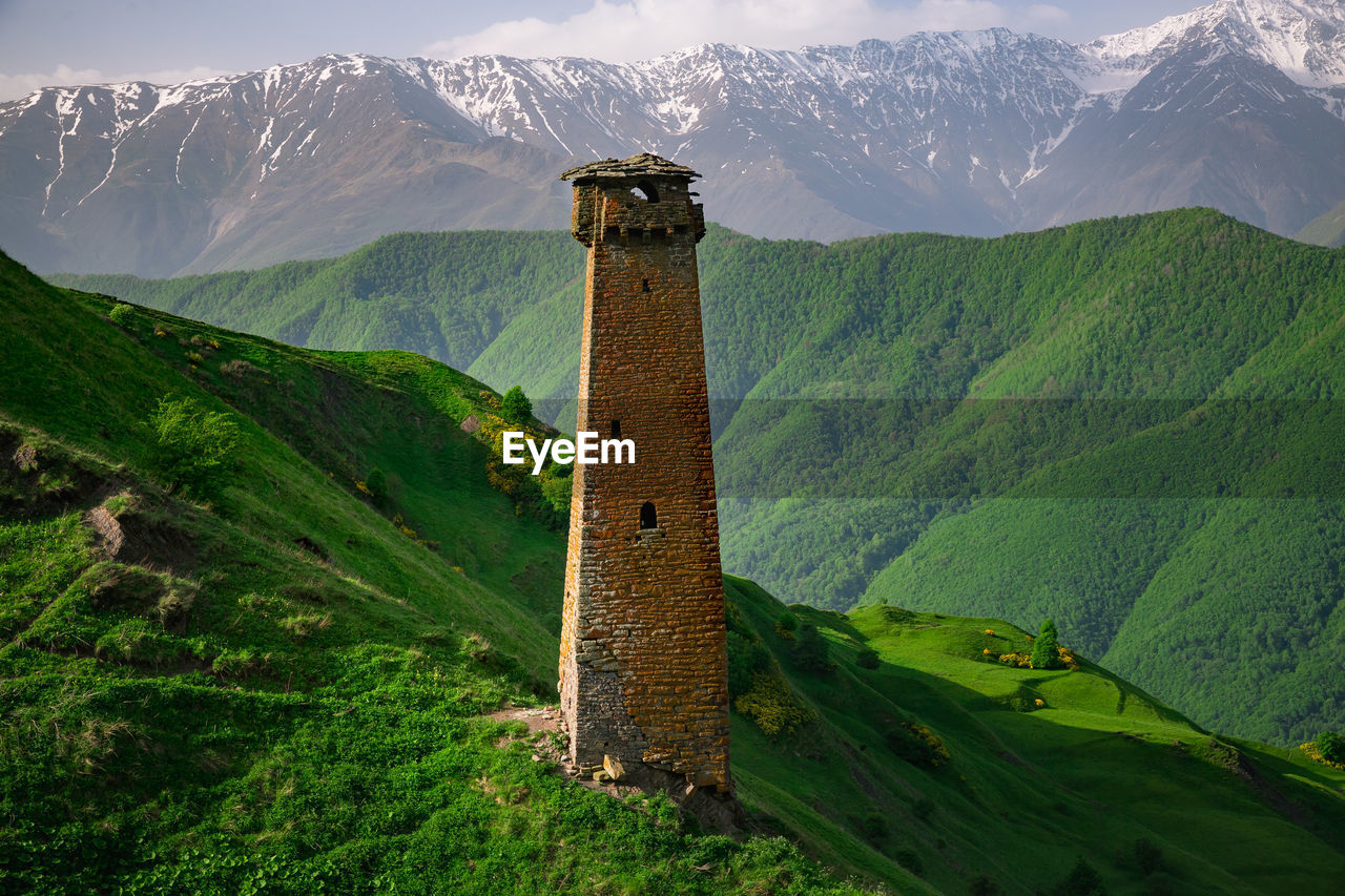 View of tower against mountain range. old ancient historical towers of the chechens