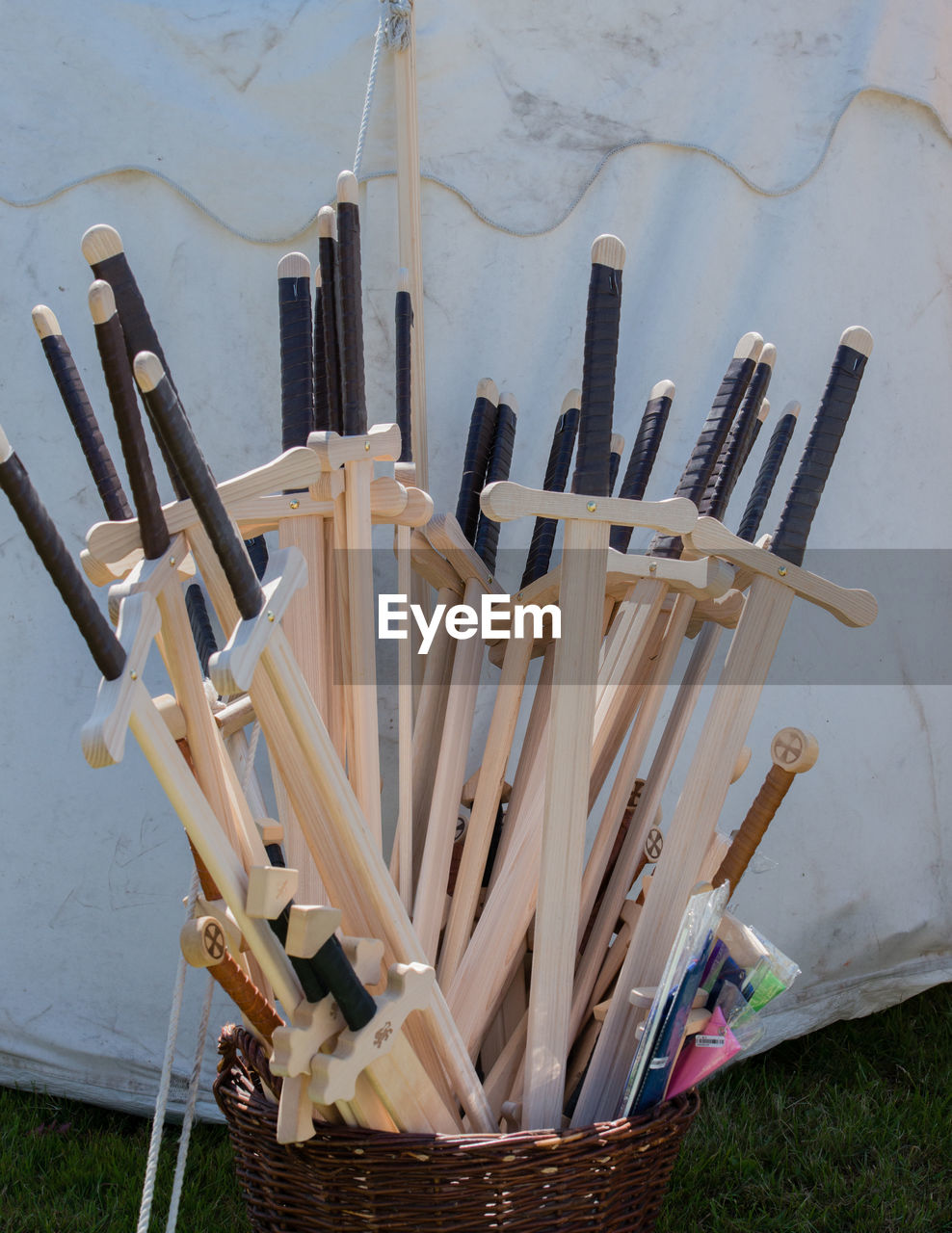 Wooden swords in basket on field