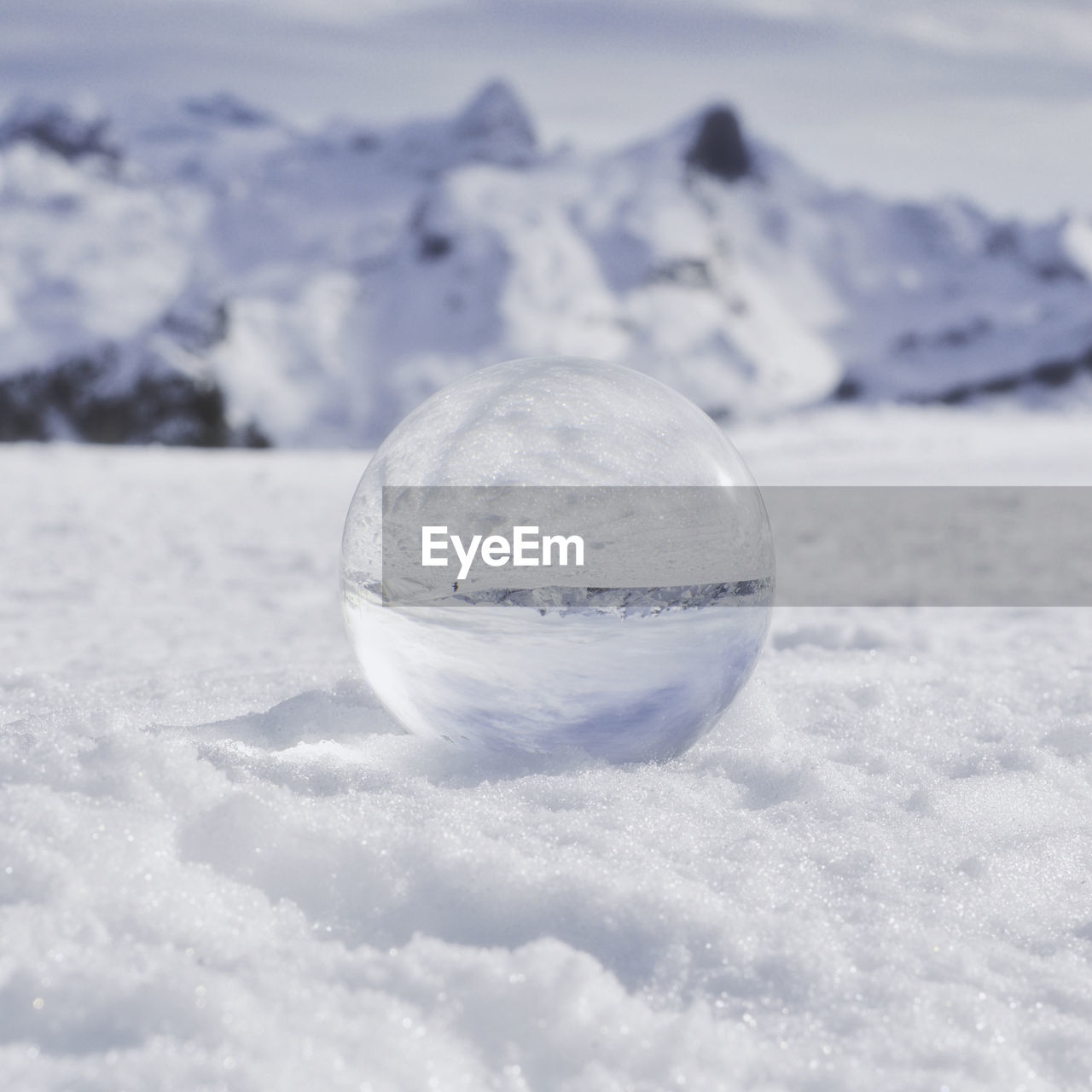 Close-up of  crystal ball on land against sky