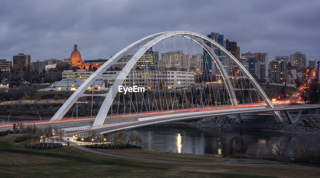 Illuminated bridge over river against buildings in city calgary 