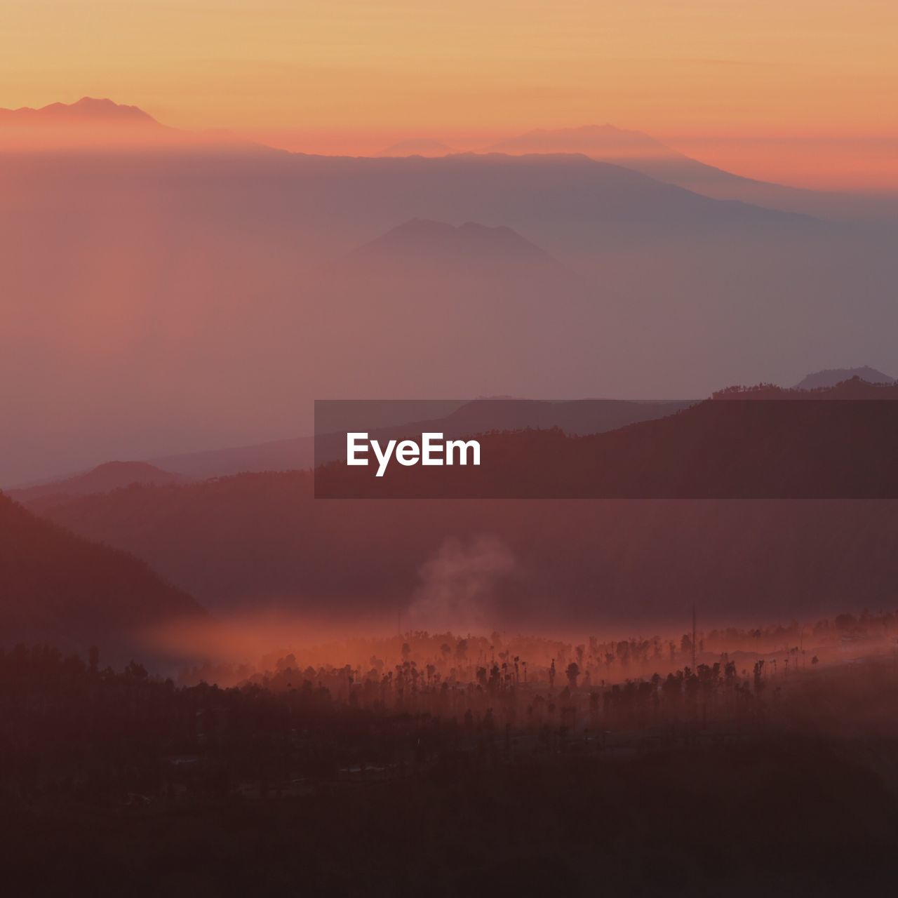 Scenic view of silhouette mountains against orange sky