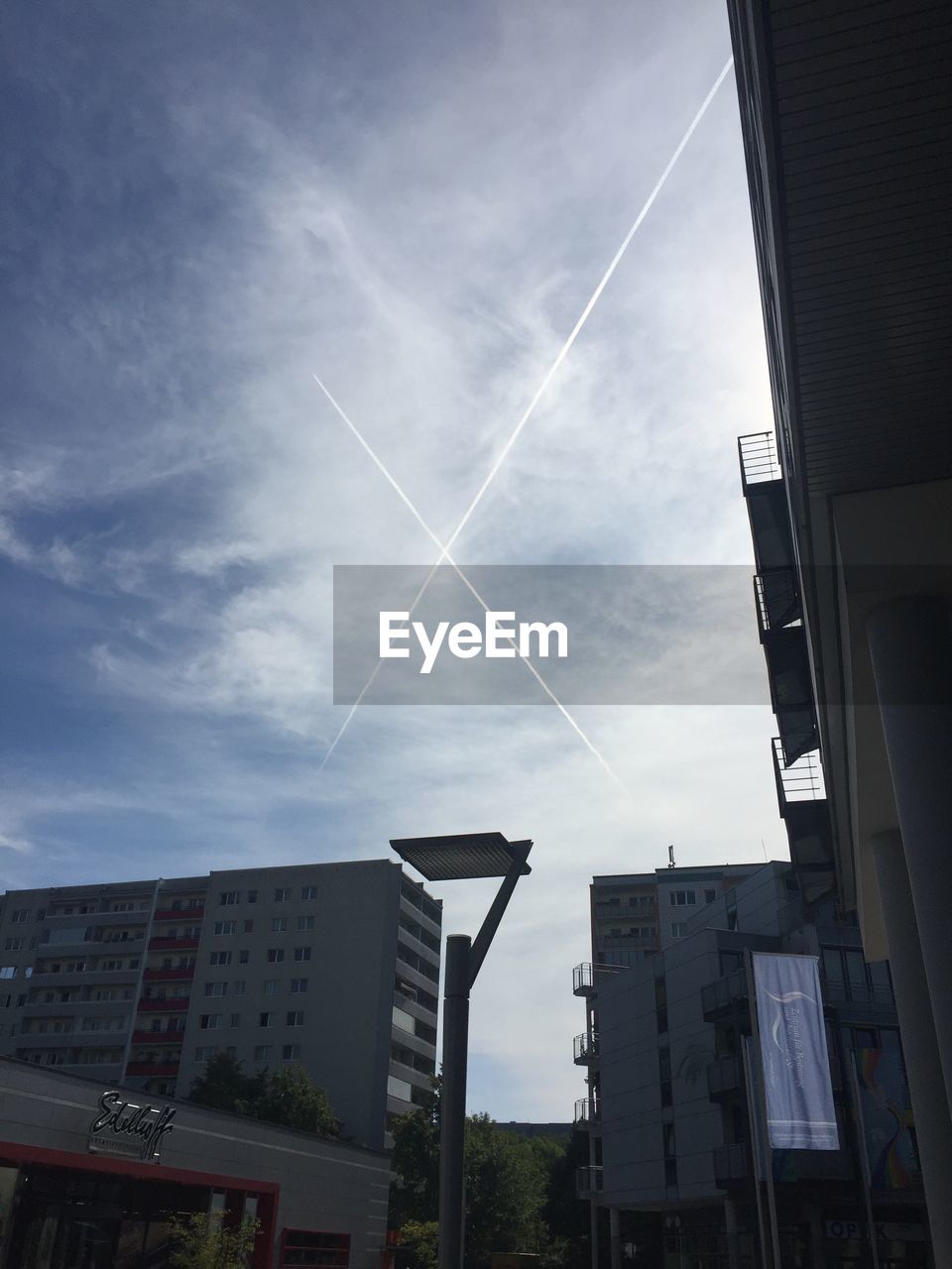 LOW ANGLE VIEW OF BUILDINGS AGAINST CLOUDY SKY