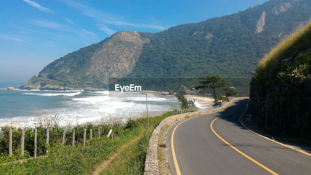 Road by sea against mountains