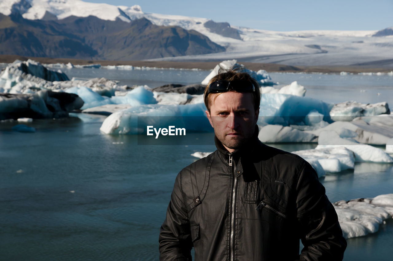 Portrait of man standing against frozen lagoon