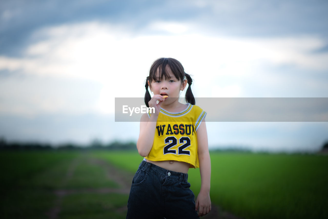 BOY STANDING ON FIELD