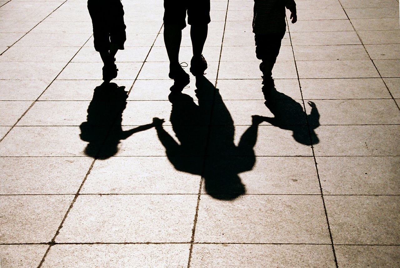 Low section of family walking on tiled floor