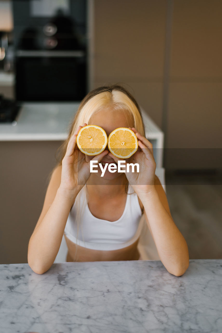 Cropped hands of woman holding orange fruit