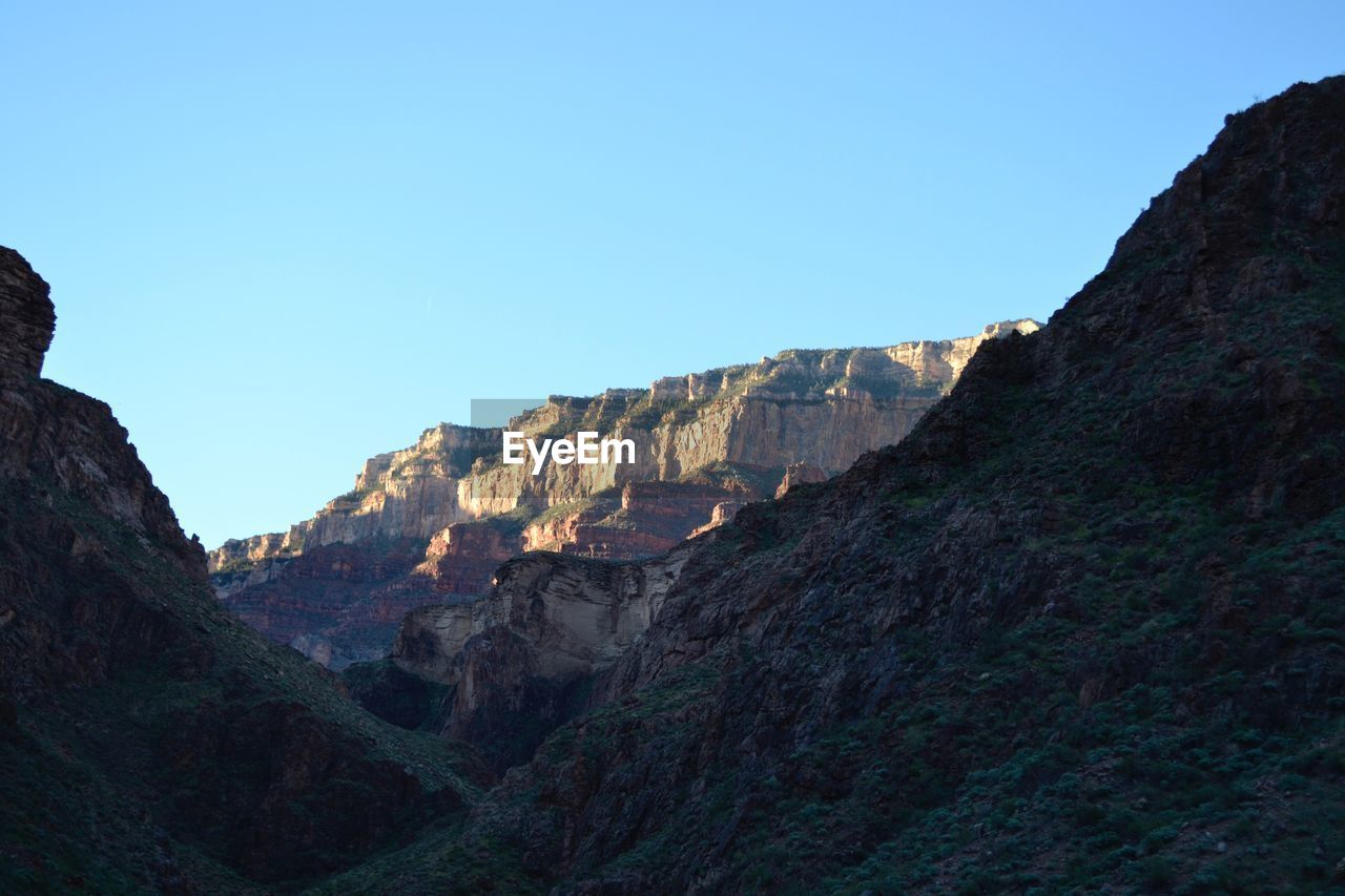 Low angle view of rocky mountains at grand canyon national park against clear sky