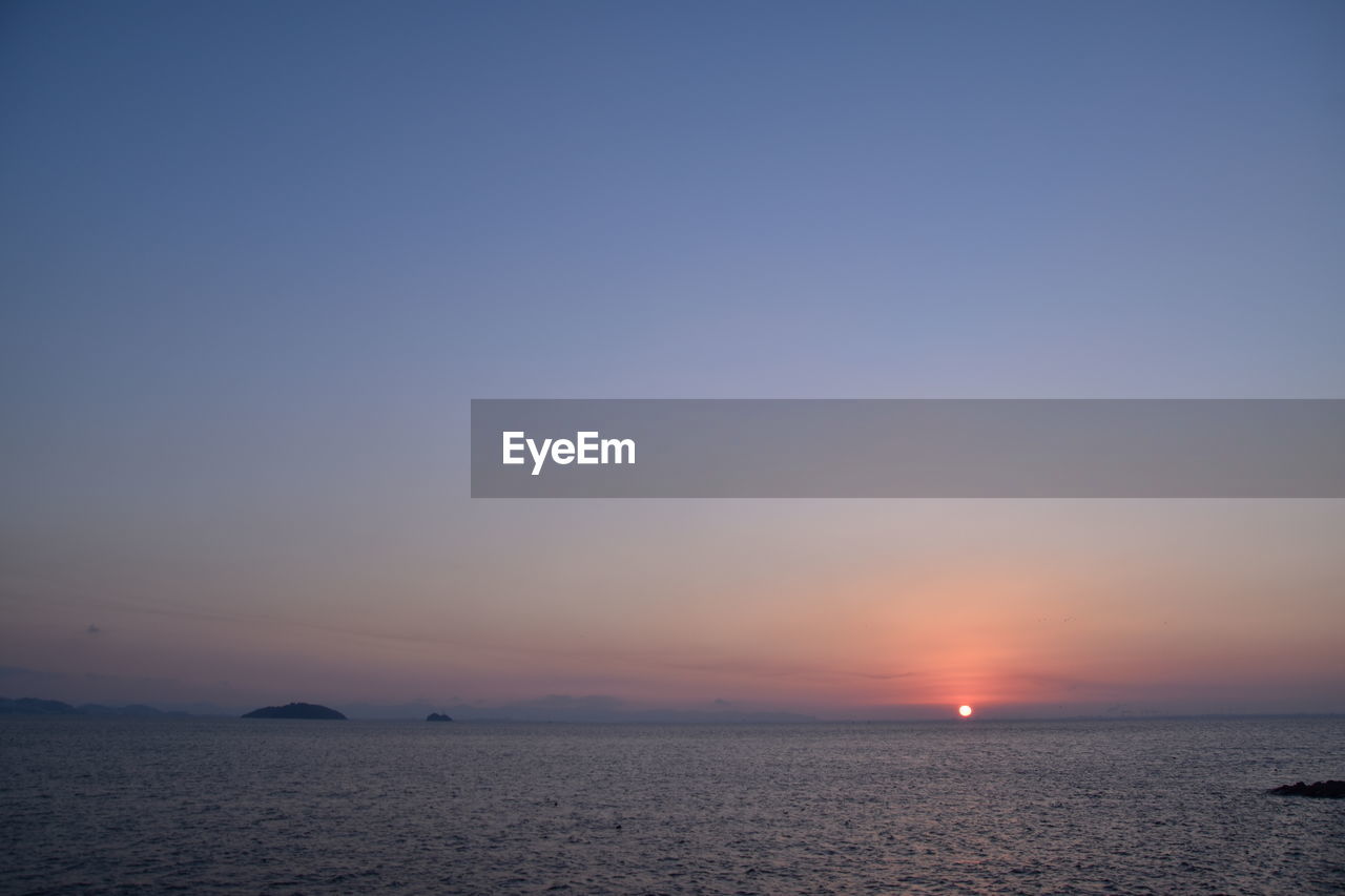 SCENIC VIEW OF SEA AGAINST SKY AT SUNSET