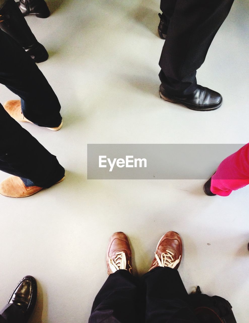 Feet of people standing on white floor