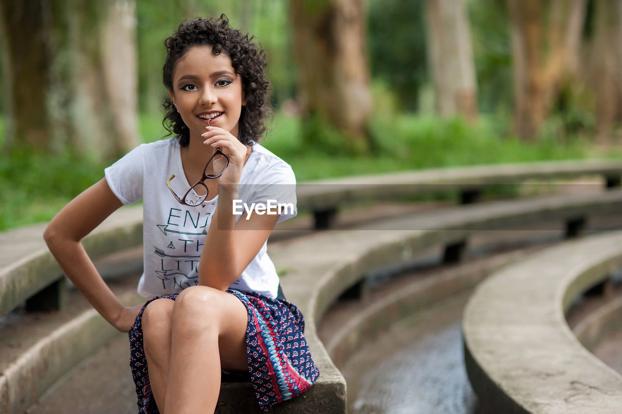 Portrait of smiling girl sitting outdoors