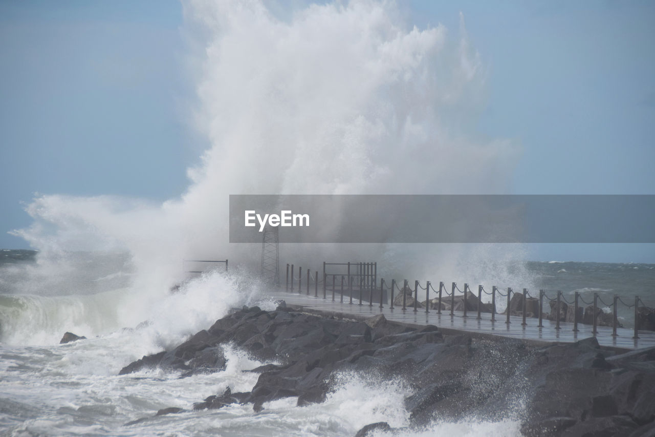 PANORAMIC VIEW OF SEA WAVES SPLASHING AGAINST SKY
