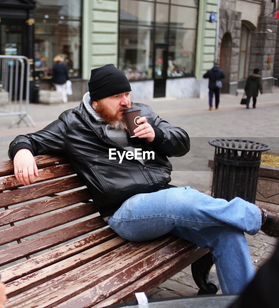 MAN SITTING ON BENCH IN SHOPPING CART