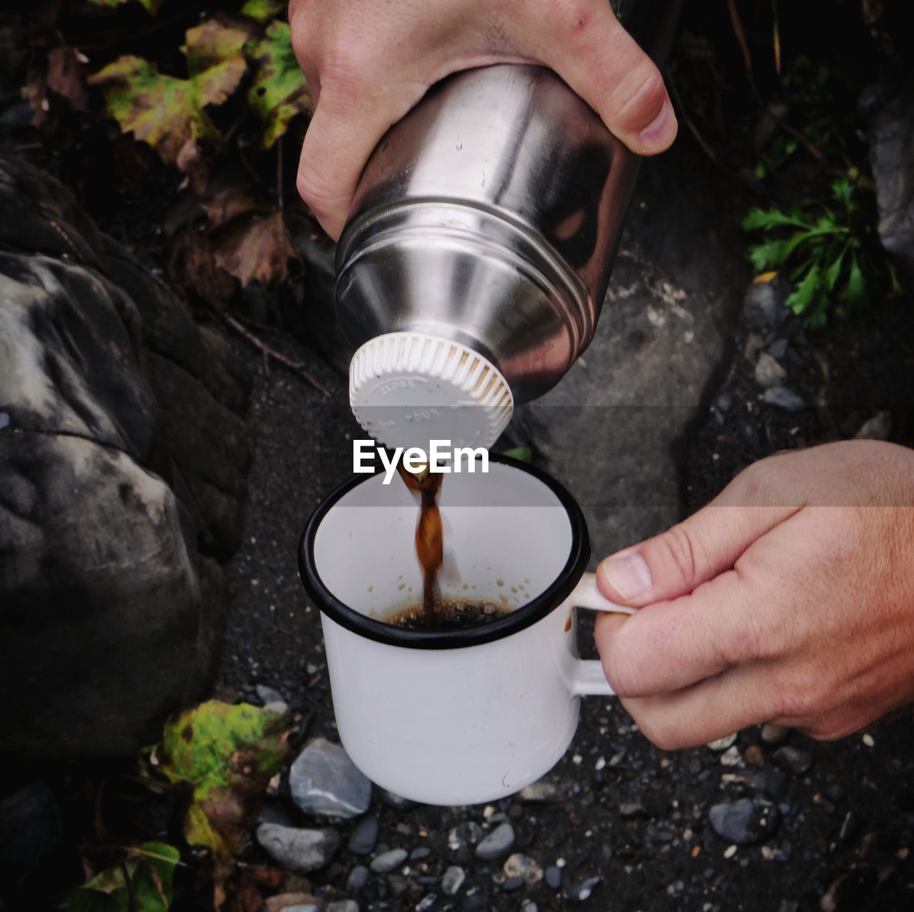 Cropped hand pouring coffee into mug