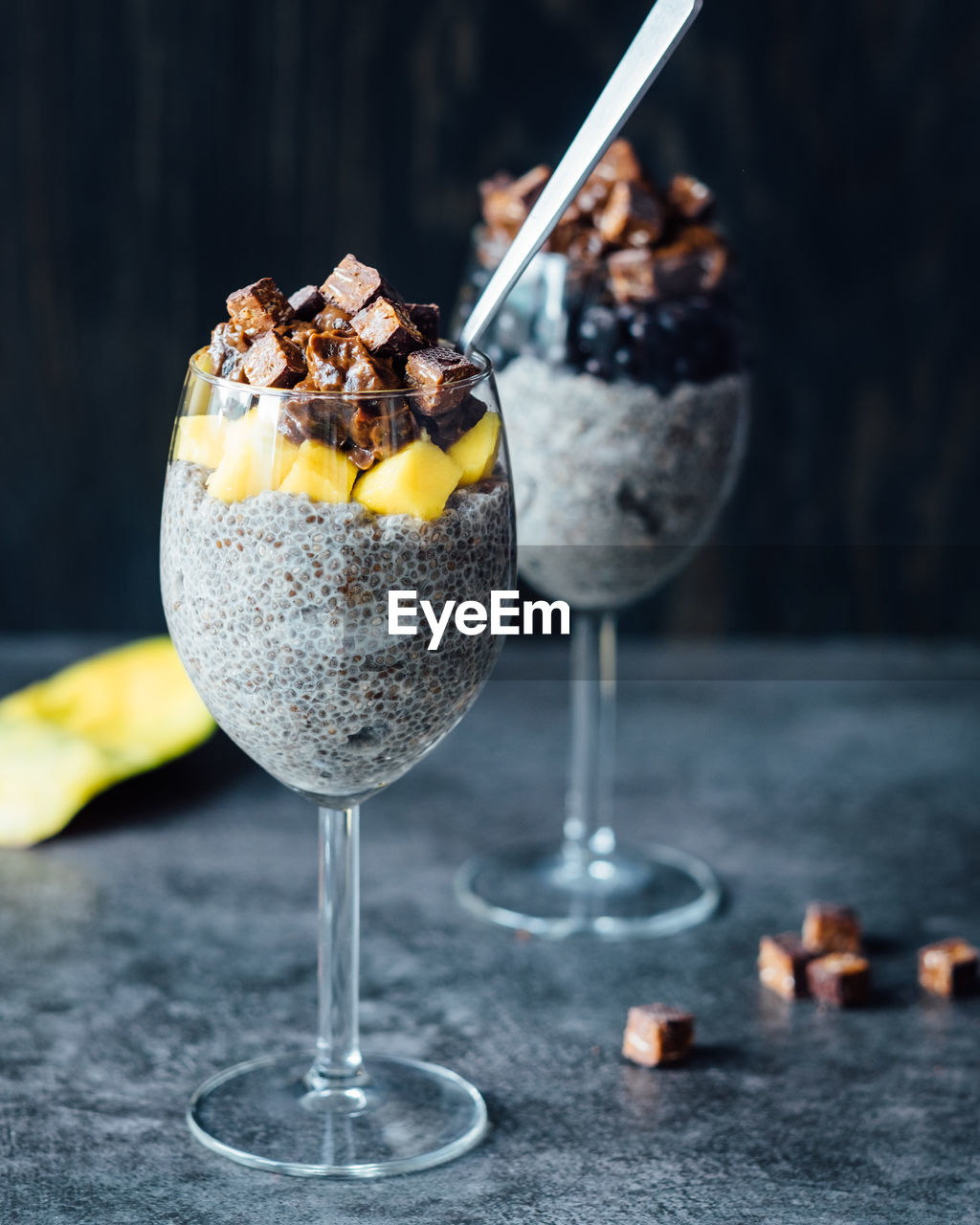 Close-up of chia pudding with chocolates and mango slices on table