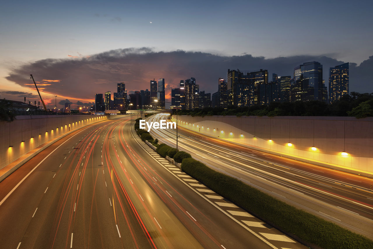 Singapore downtown skyline with light trails on highway leading toward city