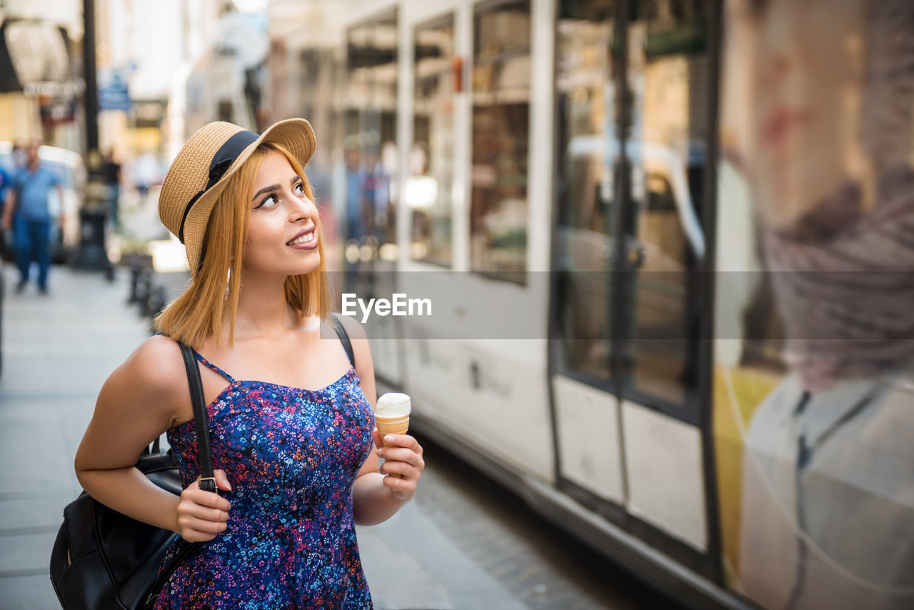 Portrait of a beautiful young woman standing by train