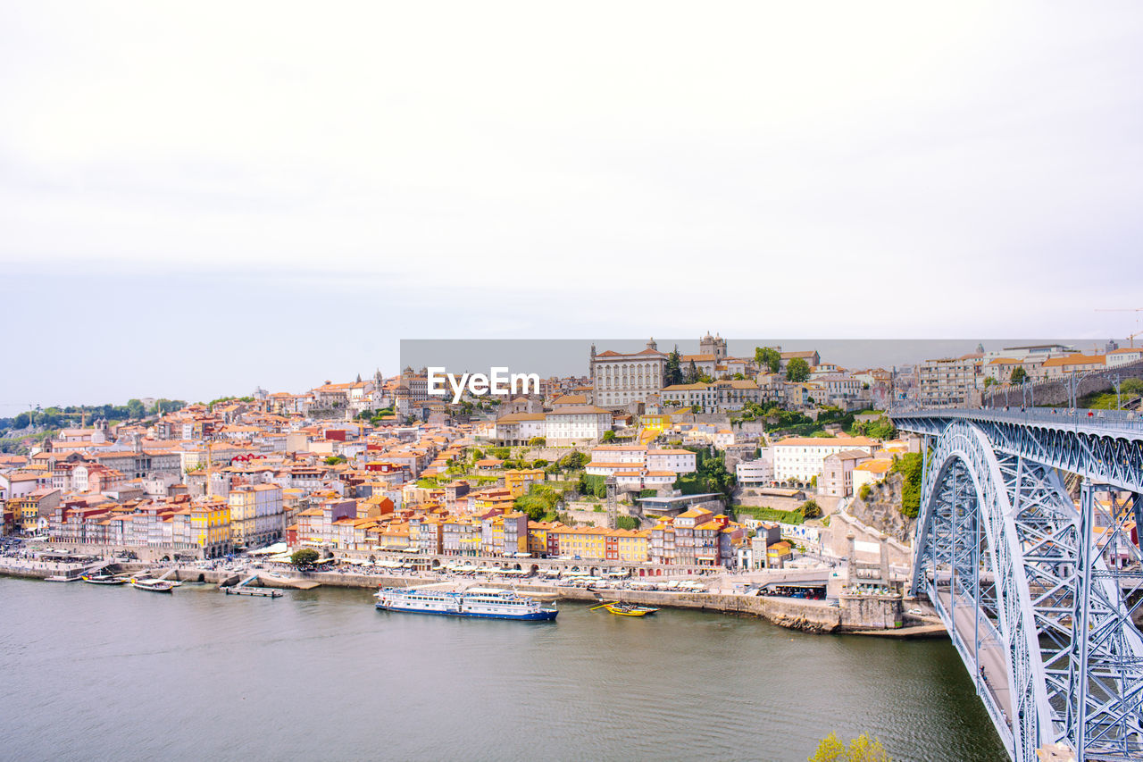 CITYSCAPE BY RIVER AGAINST SKY IN CITY