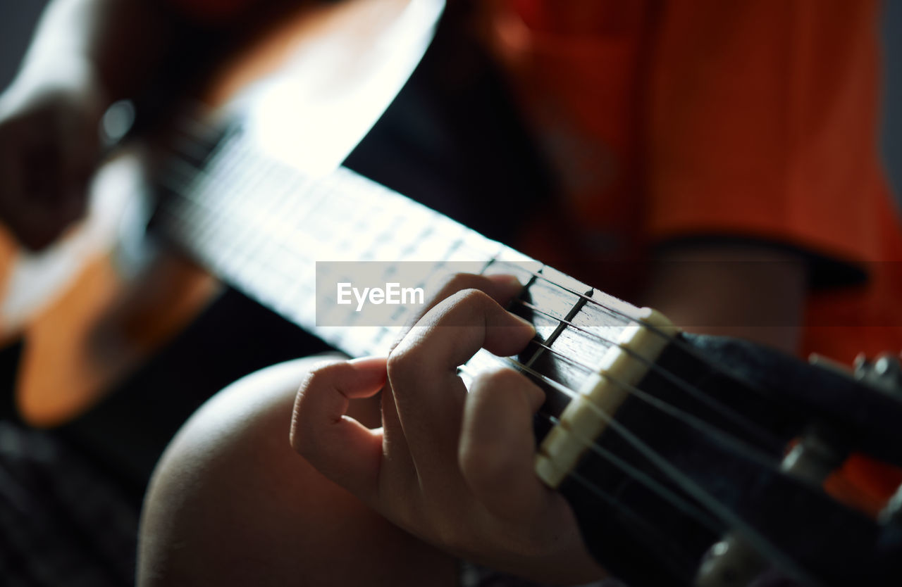 Close-up view of finger and guitar chord