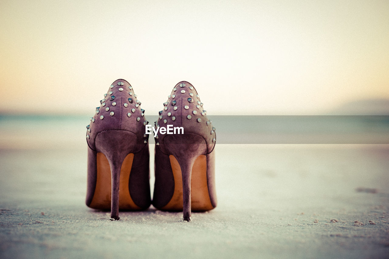 Close-up of shoes on beach