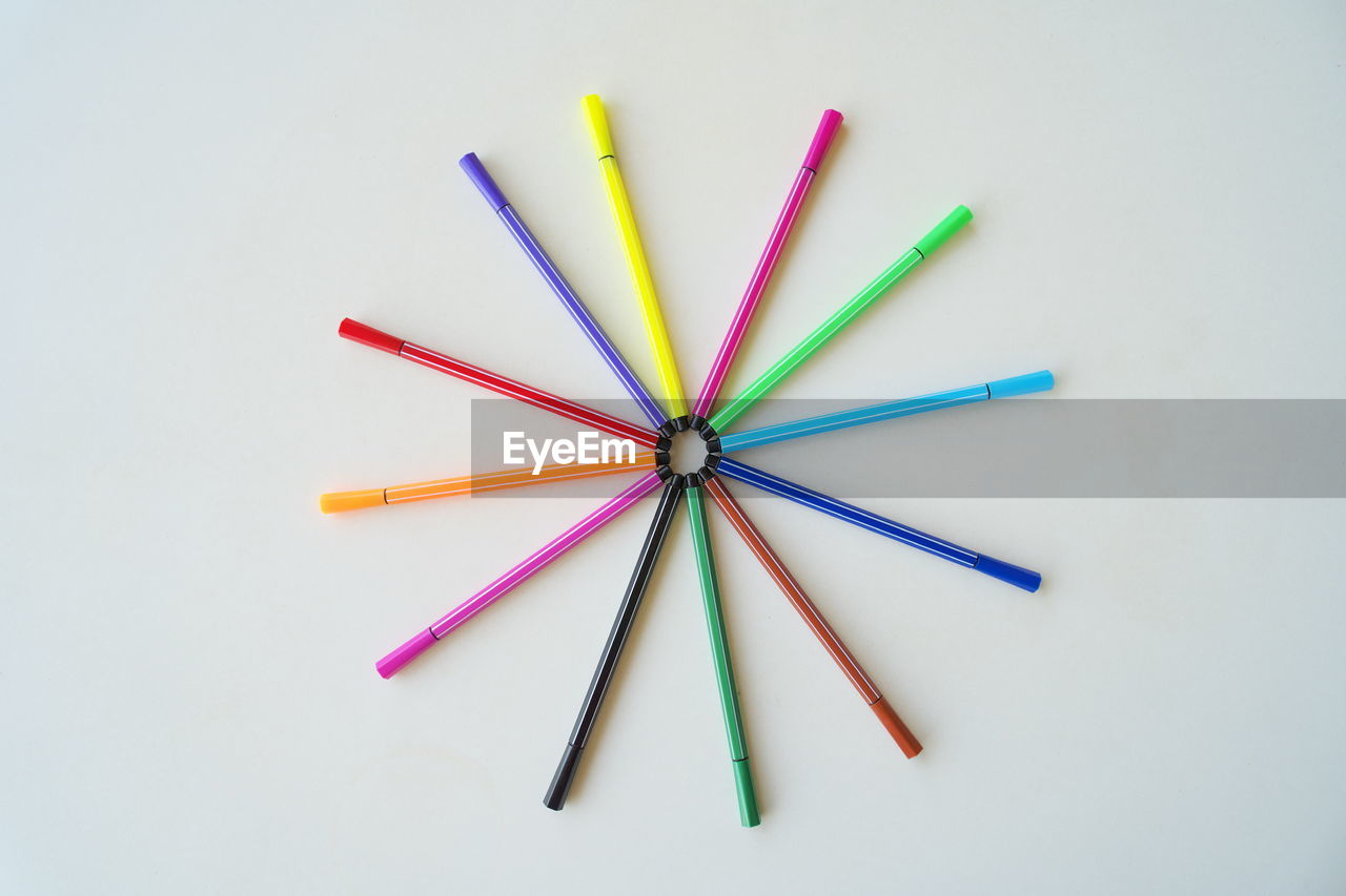 HIGH ANGLE VIEW OF COLORED PENCILS ON WHITE BACKGROUND