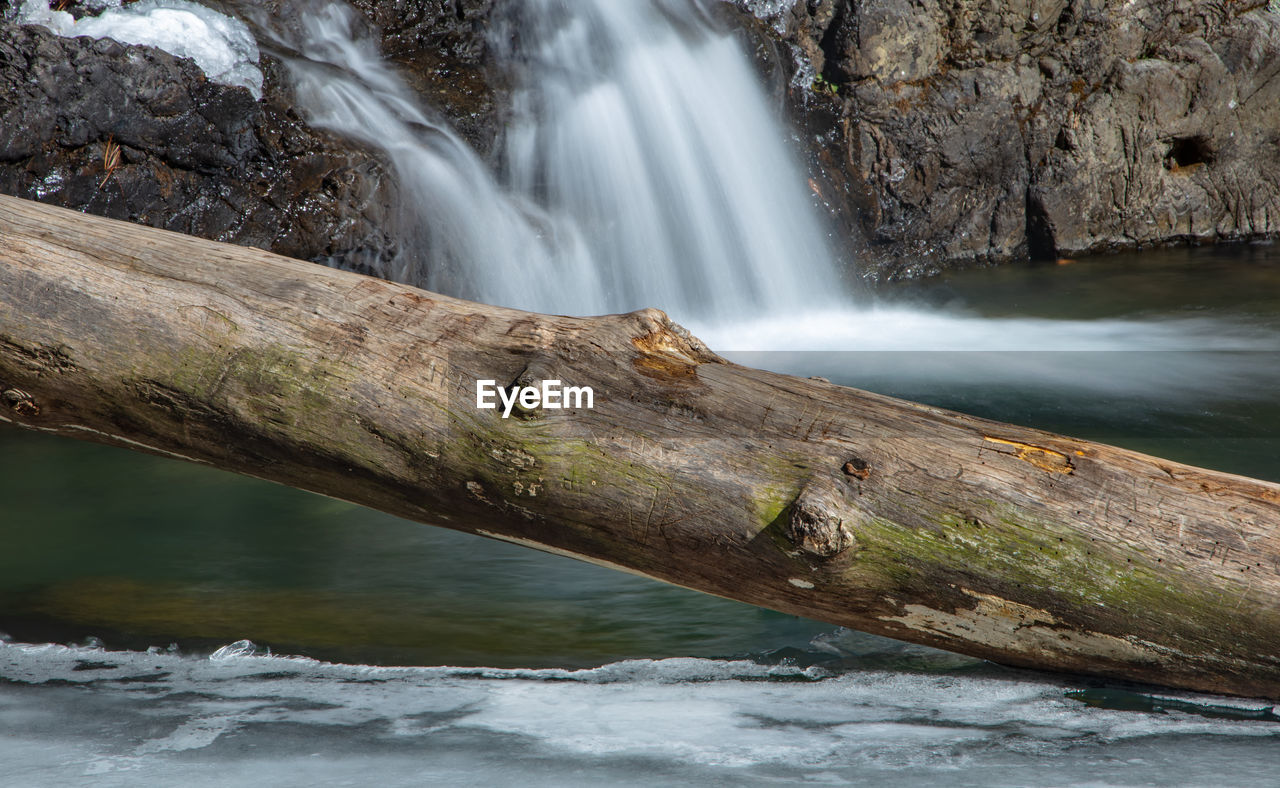 SCENIC VIEW OF WATERFALL AGAINST ROCKS