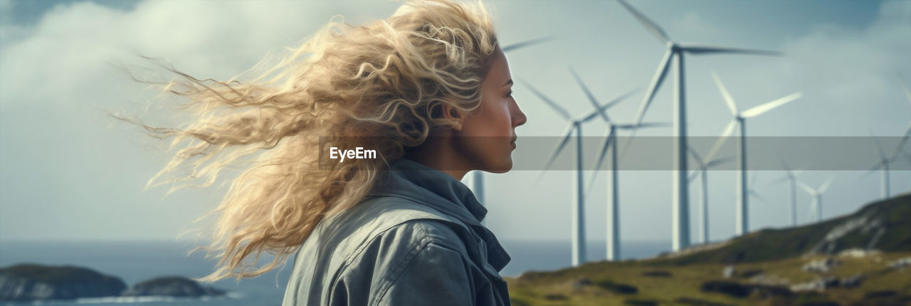 one person, environment, wind, windmill, sky, environmental conservation, blond hair, nature, hairstyle, renewable energy, women, power generation, alternative energy, long hair, adult, wind turbine, side view, land, turbine, portrait, blue, landscape, wind power, focus on foreground, beauty in nature, rural scene, day, looking, outdoors, environmental issues, headshot, leisure activity, young adult, curly hair, lifestyles, cloud, contemplation, water, female, sunlight, child, childhood, sea, profile view, standing, tousled hair, casual clothing, emotion