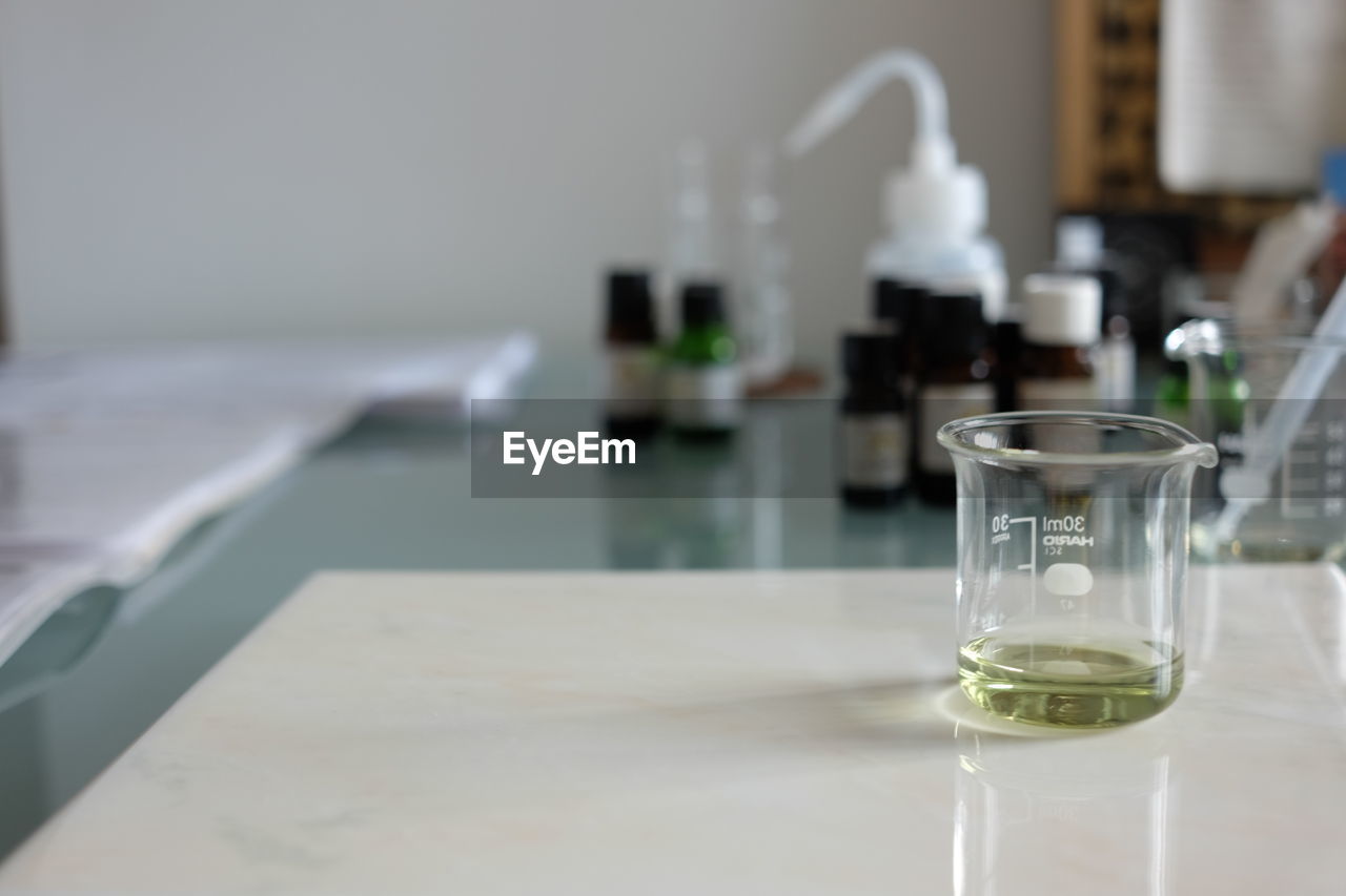 table, indoors, glass, drinking glass, household equipment, food and drink, drink, no people, refreshment, business, furniture, focus on foreground, white, water, container, bottle, absence, close-up, room, drinking water, still life