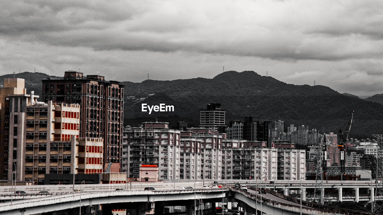 HIGH ANGLE VIEW OF MODERN BUILDINGS IN CITY AGAINST SKY