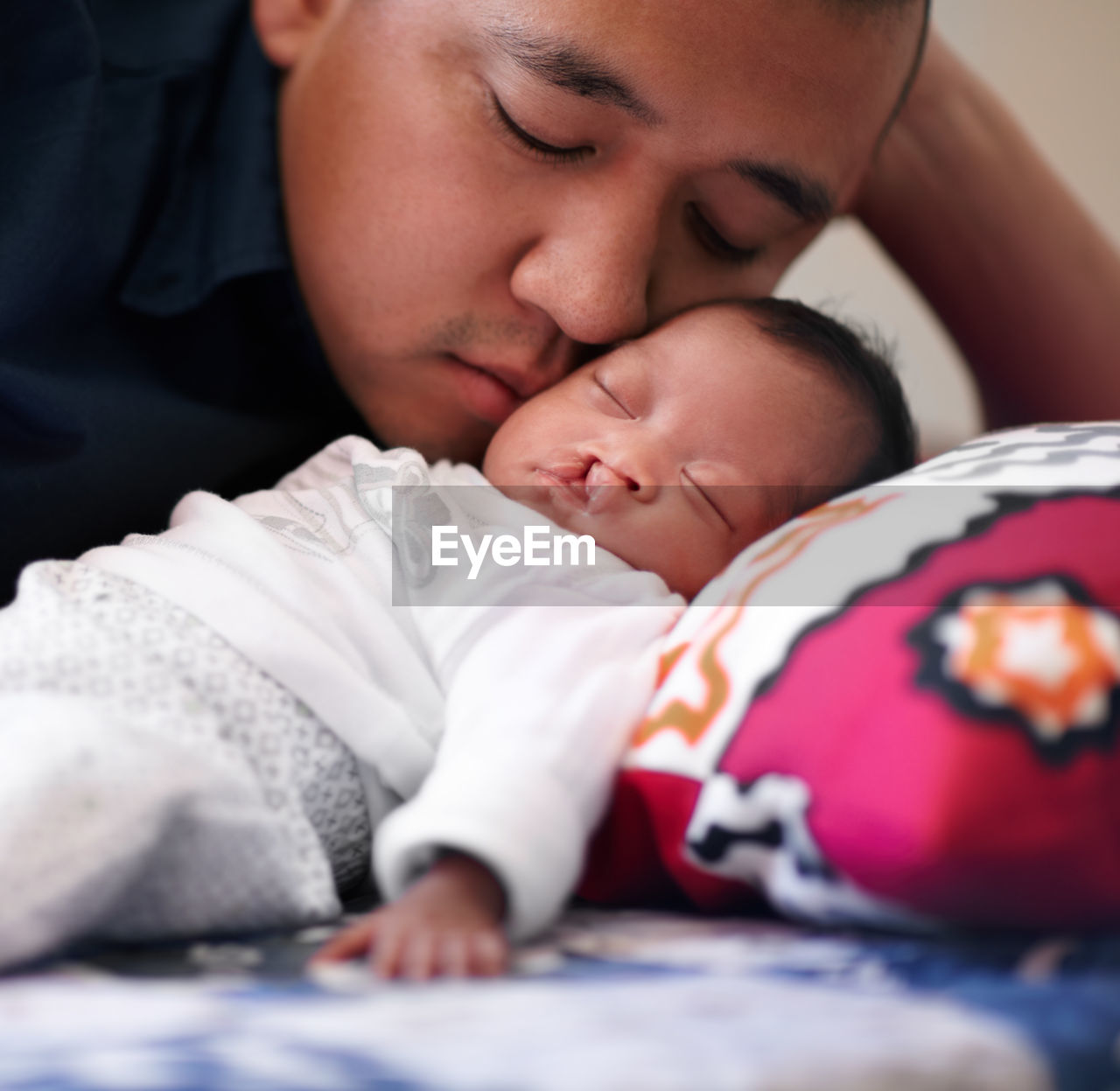 Father embracing daughter on bed