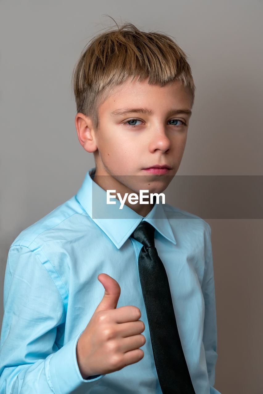 portrait of young man standing against gray background