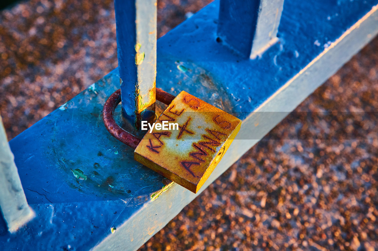 close-up of rusty padlock on railing