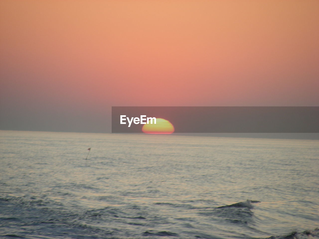 SCENIC VIEW OF SEA AGAINST ORANGE SKY DURING SUNSET